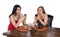 Two women sitting coffee cell phones