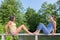 Two women sitting opposite on bridge railing