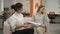 Two women sitting on sofa in office talking and discussing work schedules emotionally communicating and laughing, office