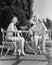 Two women sitting together in a back yard