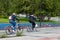 Two women spend a weekend in the park renting bicycles and ride a specially designated path against the background of green trees