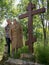 Two women stand next to a wooden cross