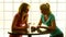 Two women standing at a table drinking wine