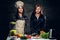 Two women start to prepare vegetable juice in a blender.