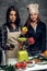 Two women start to prepare vegetable juice in a blender.