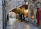 Two women stop at a refreshment stand in a narrow cobblestoned lane of the Old City of Jerusalem