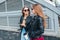 Two Women Talking in the City.Outdoor lifestyle portrait of two best friends hipster girls wearing stylish Leather