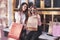 Two women talking after shopping on the street near the window