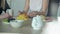 Two women talking at a white table with fruit and drink tea.