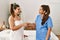 Two women therapist and patient shake hands standing at beauty center