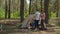 Two women and two boys having summer camping vacation in forest. Happy family of two mothers and two sons playing in