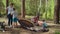 Two women and two boys having summer camping vacation in forest. Happy family of two mothers and two sons put up tent