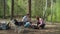 Two women and two boys having summer camping vacation in forest. Happy family of two mothers and two sons put up tent