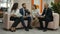 Two women and two men sit on the devanchiki in the office and discuss the documents they hold in their hands, office