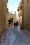 Two women walking down a narrow alley in the ancient city of Mdina, Malta