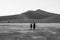 Two Women Walking in Front of Big Daddy Dune at Dawn