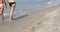 Two women walking at seashore with the feet in the water