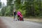 Two women walking and talking together on a trail with a baby stroller