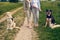 Two women walking their dogs on a rural dirt road