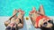 Two women with watermelon slices playing with water and looking at camera, hotel