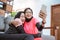 two women wearing hijab sportswear laugh and hug while on a video call with a cellphone