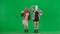 Two women in white and pink balaclavas posing in front of camera as models. Freak women in fur coats on green background