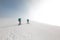 Two women on a winter hike. Girlfriends with trekking sticks go along a snow-covered mountain path. Girls with backpacks and