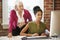 Two Women Working At Computer In Contemporary Office