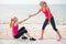 Two women workout on the beach