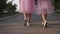 Two womens legs in tulle skirts and sneakers walking outdoors
