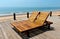 Two wooden beach chairs on deck overlooking the ocean