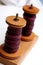 Two wooden bobbins with yarn