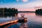 Two wooden chairs on a wood pier overlooking a lake at sunset