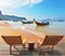 Two wooden chaise lounges and native boats