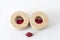 Two wooden circles with little red heart shape buttons and shinny red lips