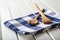 Two wooden cooking spoons on blue towel on wooden table.
