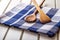 Two wooden cooking spoons on blue towel on wooden table.