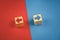 two wooden cubes with red and blue arrows on a red and blue background look in different directions