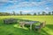 Two wooden dining tables and some sitting benches on a vast grass field with large open space. Concept of relaxation, refreshment