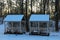 Two wooden gazebos for winter recreation in the winter forest. Wooden canopy with benches in the snow. Picturesque winter season