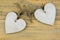 Two wooden hearts with on old wood holding with rope