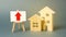 two wooden houses and a red up arrow on the sign. Real estate value increase. Supply and demand. Rising prices for housing