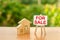 Two wooden houses and a sign stand with the word SALE on the background of nature. selling a home. Sell real estate and property