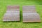 Two wooden lounge sunbeds standing on green grass