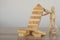 Two wooden puppets are stopping the falling wooden block tower and the strategic plans of two businessmen. Construction business p