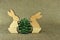 Two wooden rabbits holding a bump tree on eco-friendly fabric.