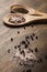 Two wooden spoons with salt and pepper on a wooden table