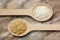 Two wooden spoons with white and brown rice grains