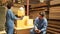 Two workers and colleagues check shipment orders stock at parcels warehouse.