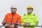 Two workers or engineers with face mask standing on a construction site or  an industrial railing